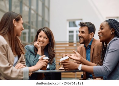 Happy creative colleagues having fun while talking and drinking coffee at office building patio.  - Powered by Shutterstock