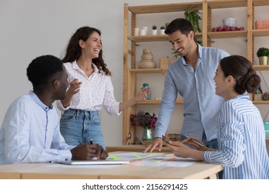 Happy creative diverse business team brainstorming on meeting, sharing creative ideas for project, discussing marketing strategy, stats report, enjoying teamwork, talking, smiling, laughing - Powered by Shutterstock