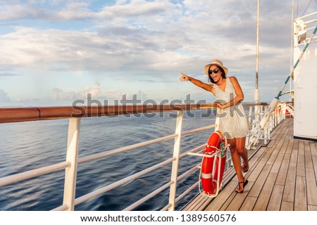Happy cruise vacation fun travel woman pointing watching whales or wildlife sighting from deck of boat on Europe summer destination cruising vacation holiday. Luxury relaxation getaway.