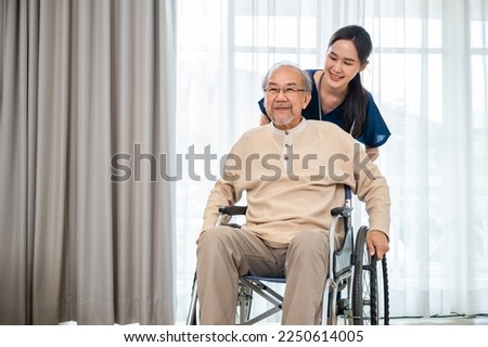 Happy curator person doctor pushing wheelchair and run elderly disabled patient freedom raising arm at hospital, senior retired man sitting on wheelchair having fun with young woman nurse, health care