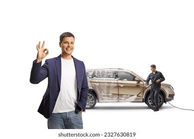 Happy customer with a SUV gesturing ok sign at a carwash isolated on white background - Shutterstock ID 2327630819
