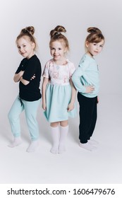 Happy Cute Adorable Blondie Triplets Girls Posing In Studio Together On Isolated Background. Childhood, Children, Twins Concept. Smiling Girls Playing Together