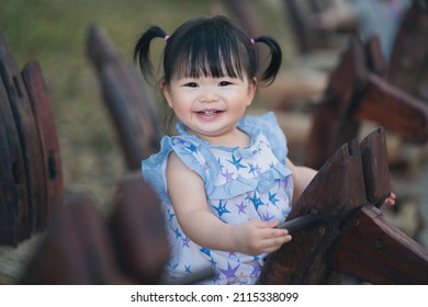 Happy cute baby playing on rocking horse in the park. 1 year 6 month baby in the park use as concept of play, health, mood and motion of baby and kid development.
