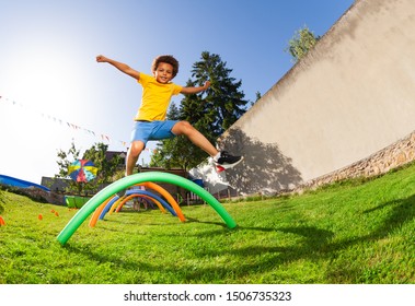 Happy cute boy jump over barriers on playground - Powered by Shutterstock