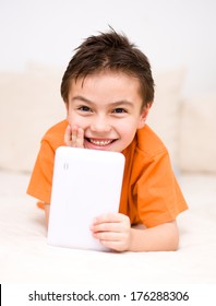Happy cute boy using tablet computer