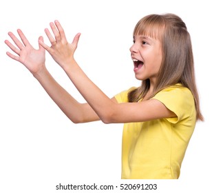 Happy Cute Child Reaching Out Her Palms And Catching Something. Half-length Emotional Portrait Of Caucasian Little Girl Wearing Yellow T-shirt, Surprised. Funny Kid Trying To Catch Something, Isolated