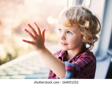 Happy Cute Girl Sitting Alone Near Window 