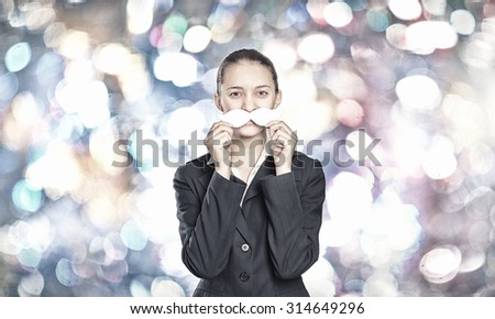 Happy cute girl trying male paper mustache