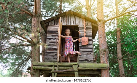 Happy cute kid playing in the treehouse in summer, happy summertime in countryside, ecological playground 