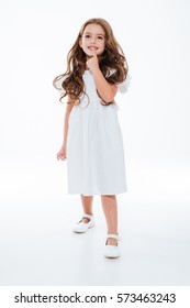 Happy cute little girl in dress smiling and walking over white background