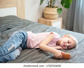 Happy cute little girl playing games on smartphone at home - Shutterstock ID 1720763650