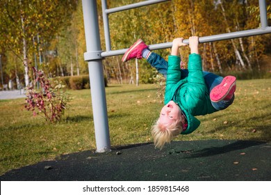 Happy Cute Little Girl Upside Down On Monkey Bars