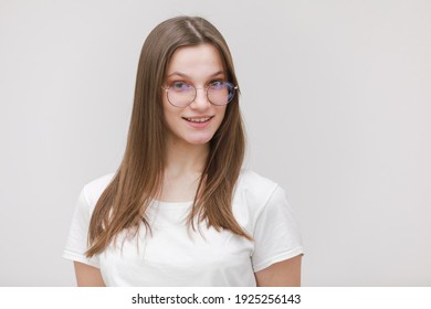 Happy cute millennial teen girl student in glasses looking at camera, smiling pretty young woman model in eyewear posing isolated on white background, head shot portrait.