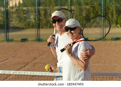 Happy cute senior couple playing tennis outdoors - Powered by Shutterstock