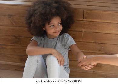 Happy Cute Small Kid Girl Orphan Holding Hand Of Foster Care Mom Sit On Floor, Smiling Little Adopted Child Find New Family, Charity Concept, Parent Children Protection, Adoption, Hope And Donation