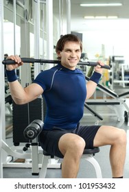 happy cutie athletic guy ,  execute exercise on sport-apparatus, in  sport-hall, look on camera and smile