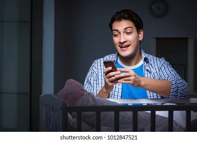 Happy Dad Looking After Newborn Baby At Night