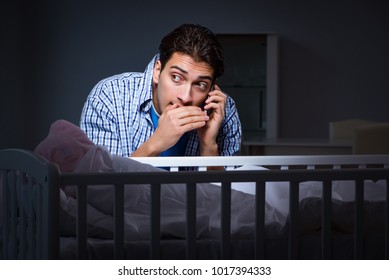 Happy Dad Looking After Newborn Baby At Night