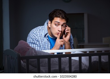 Happy Dad Looking After Newborn Baby At Night