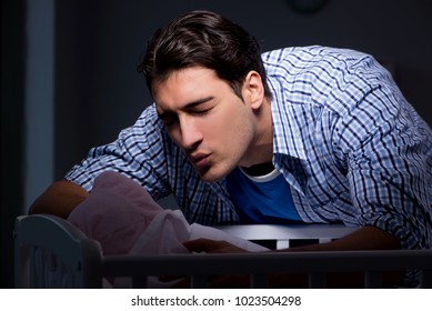 Happy Dad Looking After Newborn Baby At Night