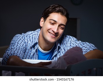 The Happy Dad Looking After Newborn Baby At Night