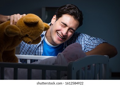 Happy Dad Looking After Newborn Baby At Night