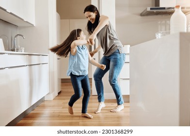 Happy, dance and a child with a mother in the kitchen, bonding and quality time together. Smile, laughing and a mom teaching her daughter with dancing, love and happiness with fun in a house - Powered by Shutterstock