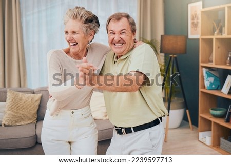Happy, dance and senior couple in a living room, smile and fun while being silly in their home together. Happy family, love and man with woman dancing, laughing and goofy while enjoying retirement