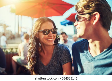 happy dating couple at outdoor restaurant with lens flare and shot with selective focus - Powered by Shutterstock