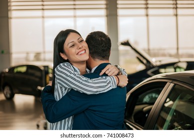 Happy Daughter Hugging Her Father After Buying Her First Car.