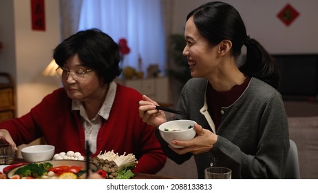 Happy Daughter In Law Talking To Her Senior Mother While They Are Enjoying Lavish Family Reunion Dinner At Home On Chinese New Year's Eve.