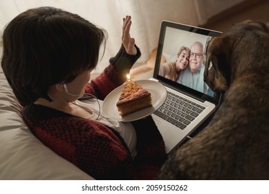 Happy daughter and senior parents doing video call birthday party at home with pet dog - Family, remote meeting concept - Powered by Shutterstock