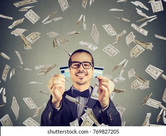 Happy Debt Free Man Holding A Credit Card Cut In Two Pieces Under Money Rain  