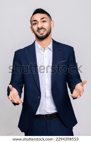 Happy delighyed serious concentrated smiled turkish man in smart ellegant suit standing on grey background in studio isolated looking at camera talking speaking inprocess. Stock photo © 