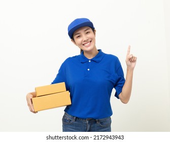 Happy Delivery Asian Woman In Blue Uniform Standing Holding Parcel Cardboard Box On Isolated White Background. Smiling Female Delivery Sending Box Package Service Worker.