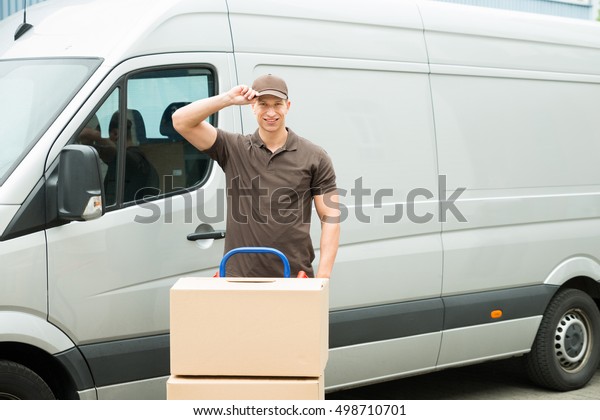 Happy\
Delivery Man With Cardboard Boxes In Front\
Van