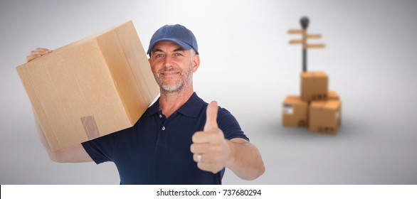 Happy Delivery Man Holding Cardboard Box Showing Thumbs Up Against Grey Background