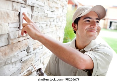 Happy Delivery Man Outdoors Ringing House Doorbell