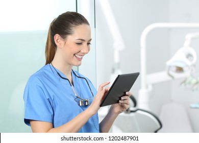 Happy Dentist Consulting Online Information In A Tablet In A Consultation