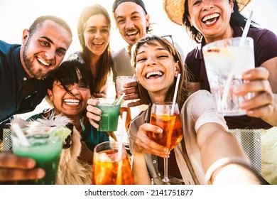 Happy different aged people taking selfie photo holding cocktail glasses outside - Cheerful family having fun together on summer vacation - Summertime lifestyle and happy hour concept - Powered by Shutterstock