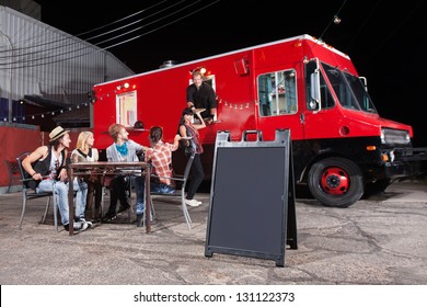 Happy diners at food truck with blank sign - Powered by Shutterstock