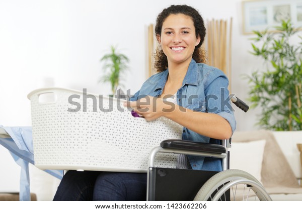 happy\
disable woman carring a basket to do\
laundry