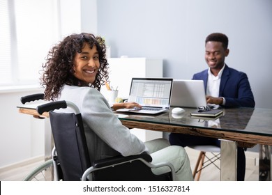 Happy Disabled Businesswoman Working On Laptop In Office