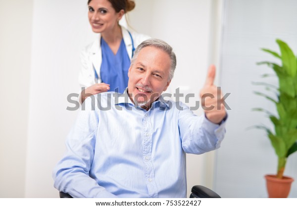 Happy disabled man and his\
nurse