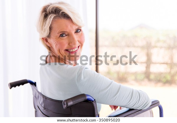 後ろを振り返る車椅子の幸せな体の不自由な女性 の写真素材 今すぐ編集