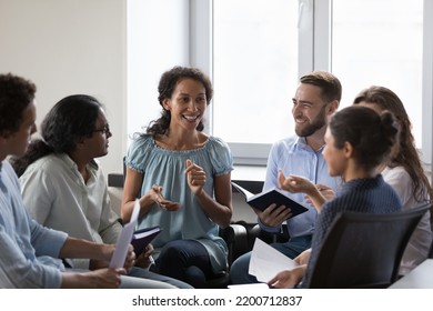 Happy diverse addicts sitting on chairs in circle, talking on group therapy meeting, discussing addiction, mental health problems. Multiethnic employees brainstorming on team training - Shutterstock ID 2200712837