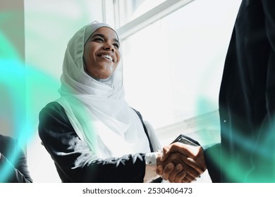 Happy diverse business people making a deal. Business agreement with a handshake.. Muslim business woman in shaking hands in deal. Arab woman with hijab in business partnership. Muslim woman at office