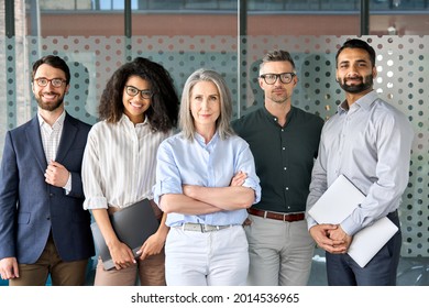 Happy diverse business people team standing together in office, group portrait. Smiling multiethnic international young professional employees company staff with older executive leader look at camera. - Powered by Shutterstock