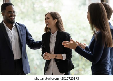 Happy diverse business team applauding coworker success. Employees congratulating promoted colleague, expressing gratitude, recognition, appreciation for good job result, work achieve