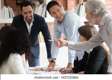 Happy Diverse Business Team Young And Old Employees Talking Brainstorming On Project Paperwork Gather At Conference Table, Smiling Workers Group Engaged In Teamwork At Corporate Briefing In Boardroom